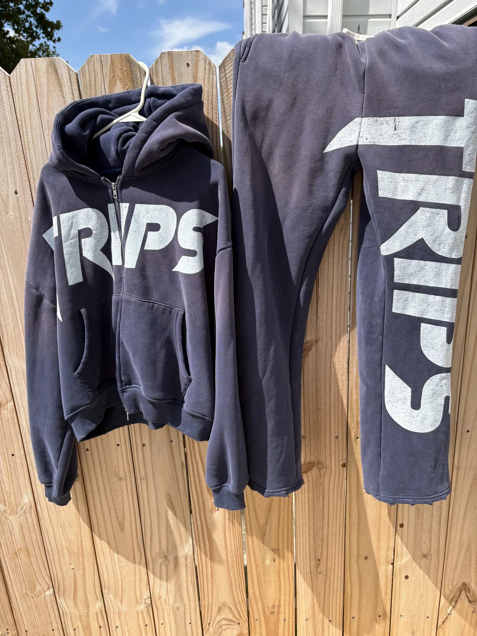 TRIPS charcoal zip hoodie and pants displayed outdoors